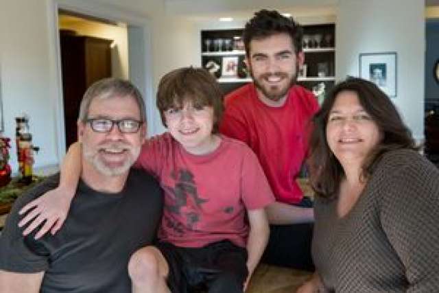 Four individuals sitting together in a cozy living room.