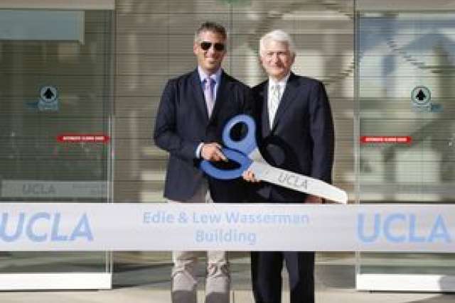 Two men holding a large key, celebrating the opening of the Edie & Lew Wasserman Building at UCLA.