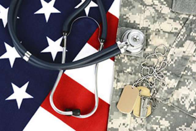 Stethoscope and dog tags on an American flag and military uniform.