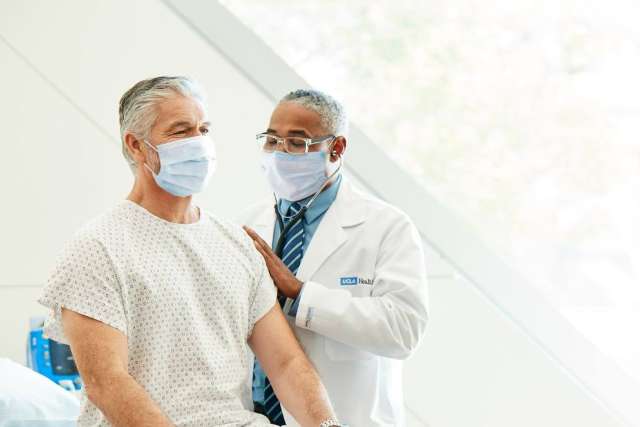 Doctor examining patient's arm in hospital setting