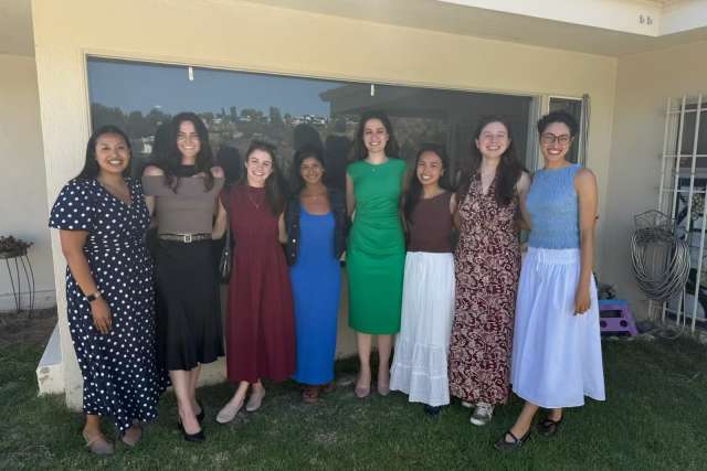 Eight women stand in line for a group photo.