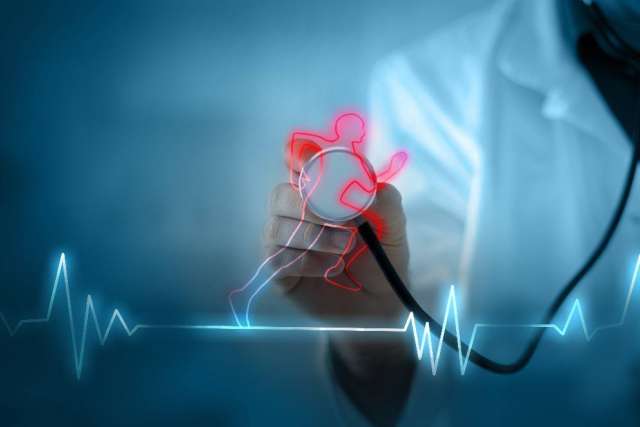 A doctor holds a heart outline with an electrocardiogram in the background.
