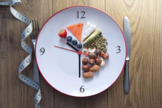 Plate arranged like a clock with various healthy foods indicating meal times.