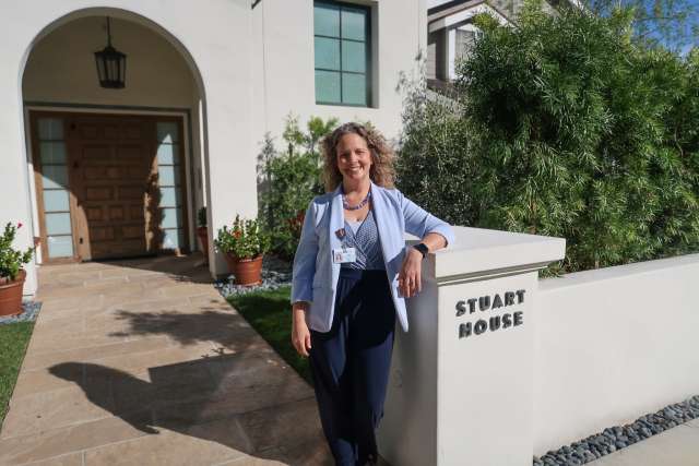 Dr. Jane Halladay Goldman stands in front of Stuart House.