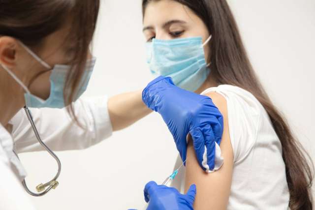 Healthcare professional administering a vaccine to a patient in a clinic.