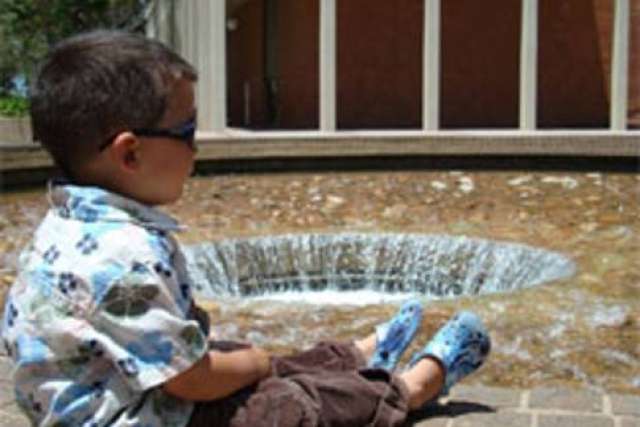 Timmy sitting at edge of circular fountain