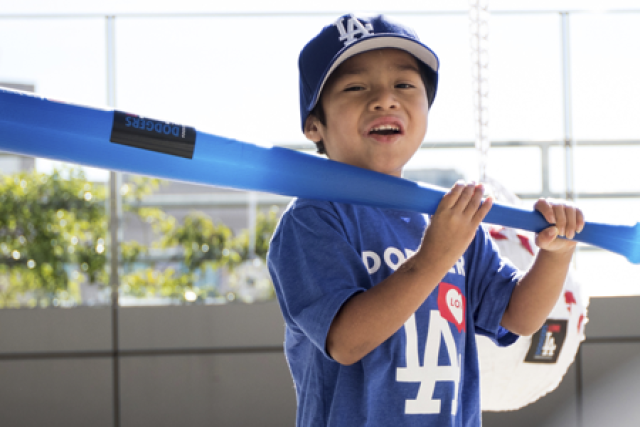 A healthy Abraham, cured of Valley Fever is ready to go home, posing with his LA Dodgers hat, t-shirt and baseball bat.
