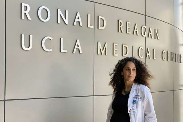 Dr. Yalda Afshar in front of Ronald Reagan UCLA Medical Center sign
