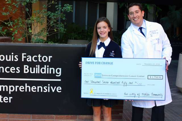 Teen fundraiser Jillian Neuner presents check to UCLA Jonsson Comprehensive Cancer Center pediatric oncologist Dr. Noah Federman