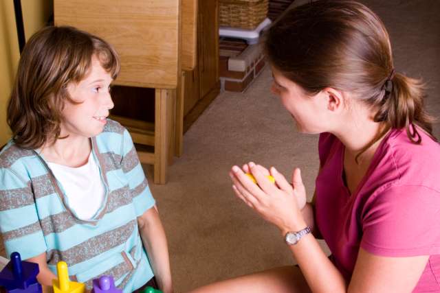 Autistic girl getting praise during therapy.