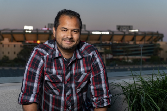 Ricardo Ortega standing in an outdoor setting and smiling for a photo, who received a kidney from his sister Yadira. 