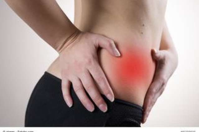 Person holding their side, indicating pain in the lower abdomen.