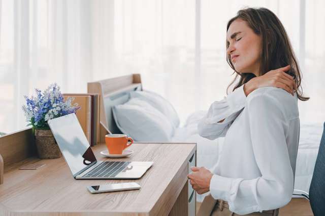 Woman rubbing her neck due to stress pain