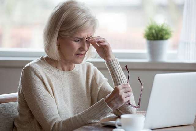 Woman rubs her eyes.