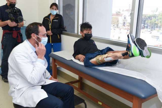 Dr. Anthony Scaduto, UCLA Health surgeon, and Chris Caron, director of physical therapy at the Orthopaedic Institute for Children, with Efrain Ordoñez Jr. at his appointment to try on his prosthetic leg after undergoing rotationplasty surgery.