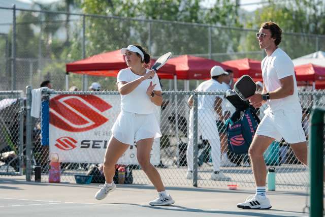 Two pickleball players at net poised to return a shot.