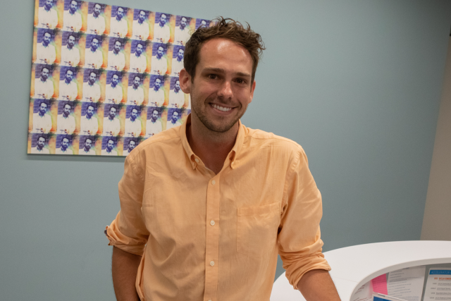 Dr. Stephen Speicher standing in a hospital waiting room, smiling and looking at the camera