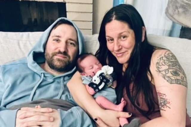 KC Brandenstein and husband, Jason Benoit, at home with their newborn daughter, James.
