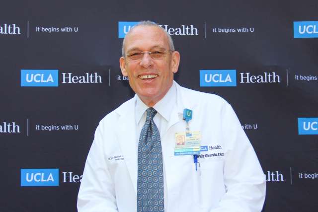 UCLA Health doctor in lab coat smiling for camera.