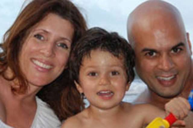 Family photo at the beach with three people enjoying the sun.