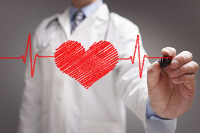 Doctor drawing a heart on a pane of glass