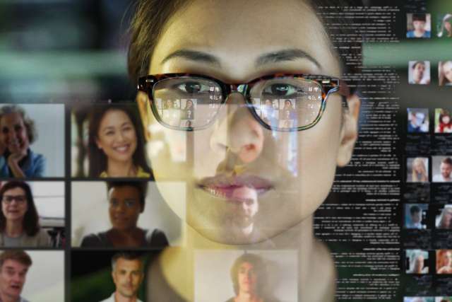 Female wearing glasses attending a virtual meeting via Zoom