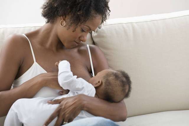 Mother nursing her baby on a couch
