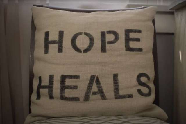 Pillow with the words ‘HOPE HEALS’ displayed in bold letters on a soft, neutral background