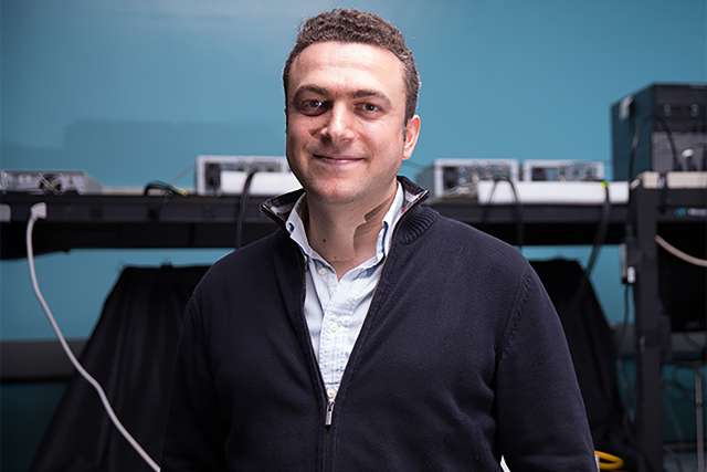 Midrange photo of Aydogan Ozcan in light blue button-down and dark blue zip-up cardigan