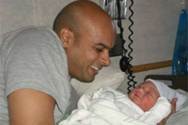 A parent gently holding a baby in a hospital setting.