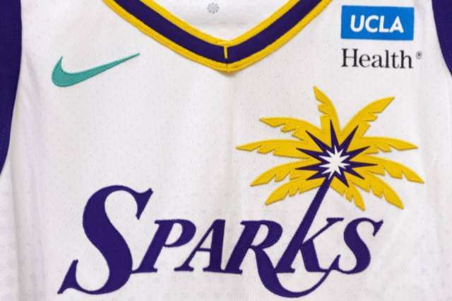 A close-up of a white WNBA jersey with the "Sparks" logo featuring a palm tree. The UCLA Health and Nike logos are visible on the upper chest.