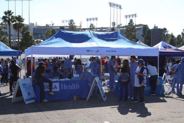 Booth at outdoor health event with staff and visitors
