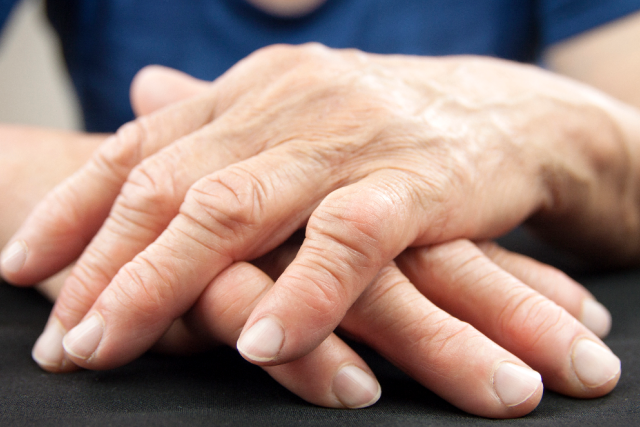 Elderly hands crossed on a table