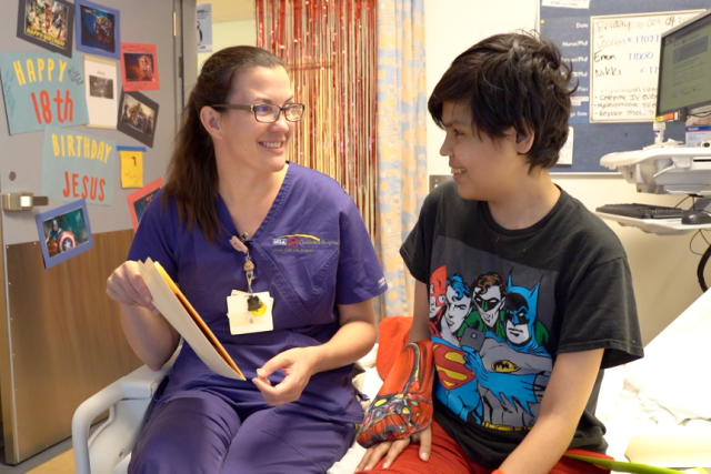UCLA Child Life Specialist Megan Pike and patient Jesus smiling together during his 18th birthday celebration at UCLA Mattel Children’s Hospital.
