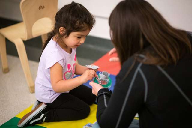Karleen Wray showing an unattached anesthesia mask to a young girl