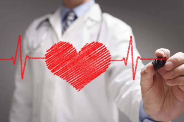 A doctor in a white lab coat draws a red heart with a heartbeat line through it.