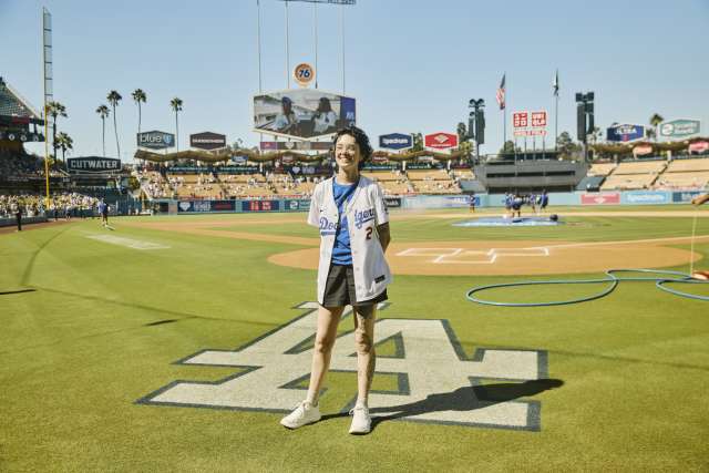 A woman stands near the LA logo on the field at Dodger Stadium.