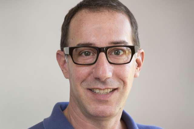 David Eisenman, MD headshot wearing glasses and blue shirt, smiling
