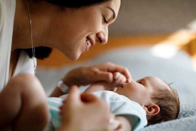 Smiling mother cradling newborn