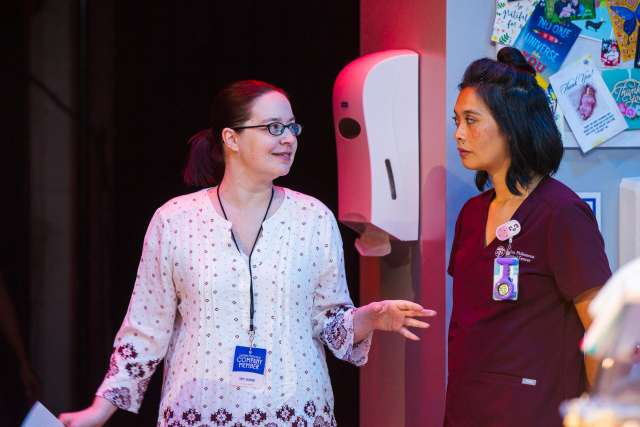 NICU nurse Emily Rogers works with actress Tiffany Villarin on stage.