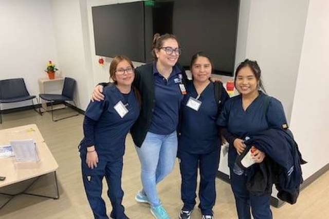 Four women with arms around shoulders