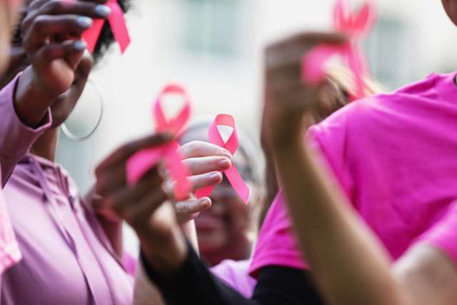 A group of women holding up breast cancer ribbons