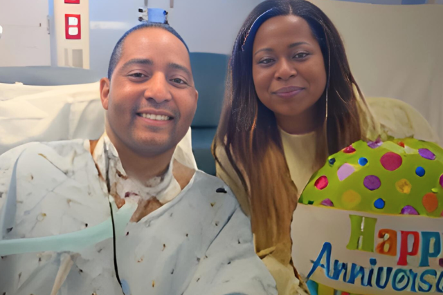 A male lung transplant patient is in a hospital bed with his wife at his side, next to a "Happy Anniversary" balloon.