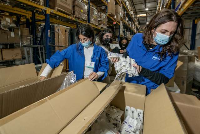 Two people moving boxes in a warehouse