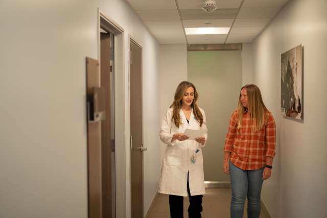 Dr. Farnaz Haji and patient Heather Hatchman, a Ventura elementary school teacher, walk together down a clinic hallway.