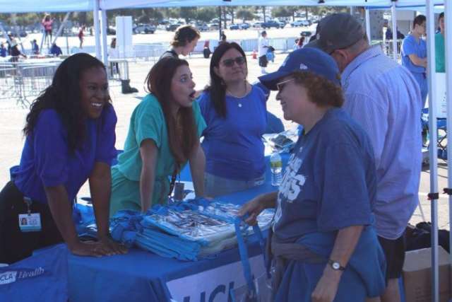 Fam Care Village health booth with volunteers talking to visitors