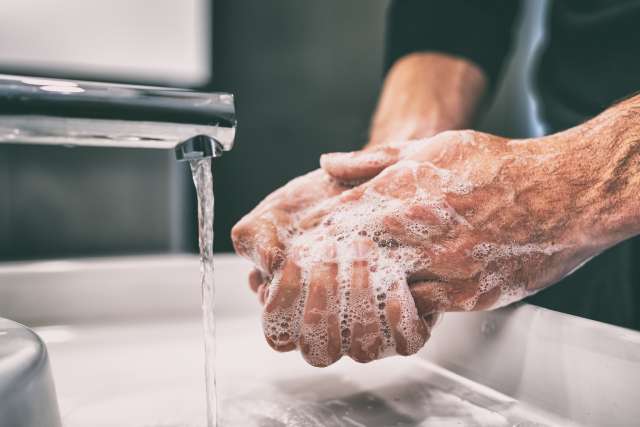 Man washing his hands in soap and water
