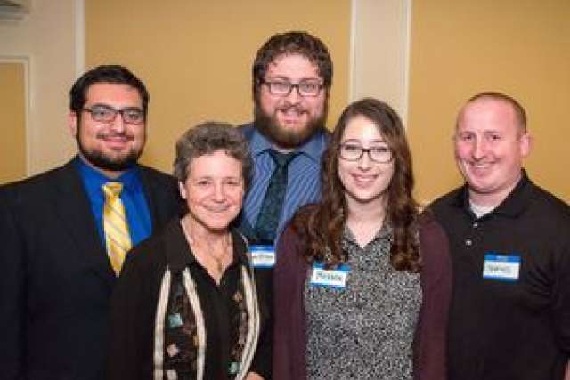 Group photograph of five individuals, all with blurred faces, in a social setting.