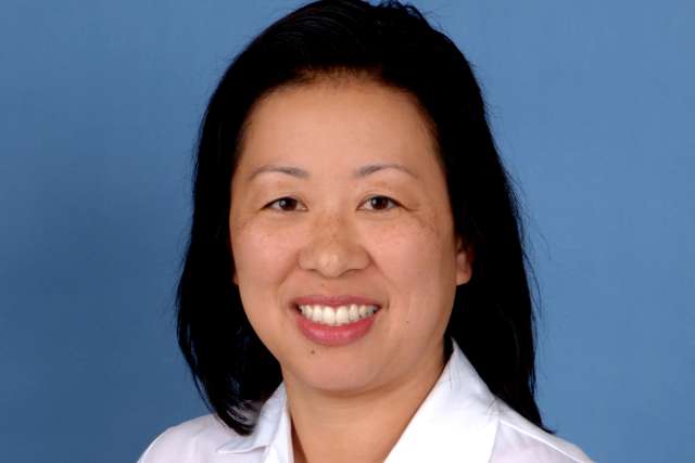 Alice A. Kuo, MD smiling headshot in white coat