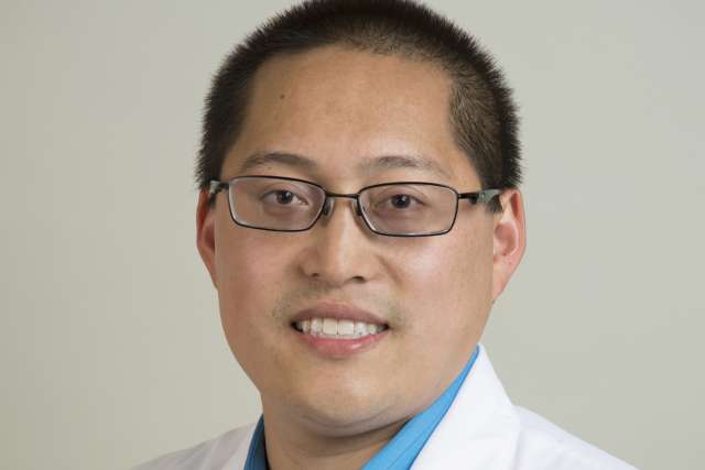 Person in white coat and glasses, professional headshot
